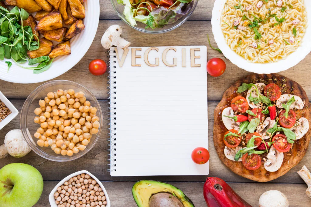 This image has an empty alt attribute; its file name is veggie-lettering-notebook-surrounded-by-veggie-food-1024x683.jpg