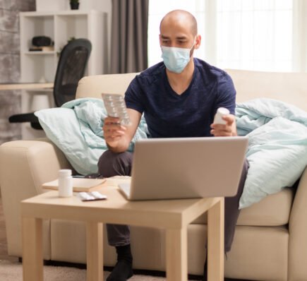Man holding different pills during online doctor consultation, symbolizing the unlimited cancer risk and importance of medical guidance.