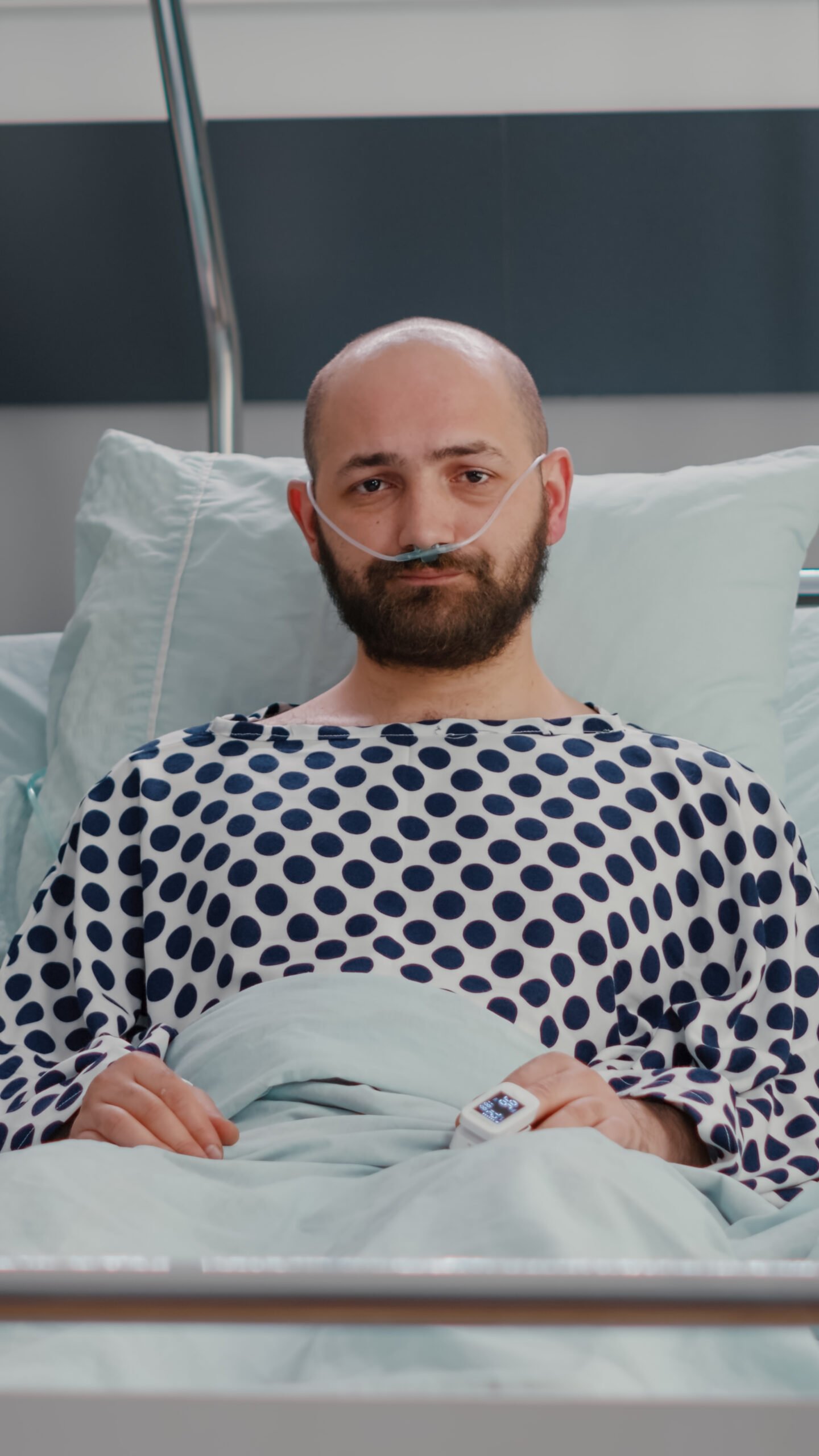 Brain cancer patient lying in hospital bed with nasal oxygen tube
